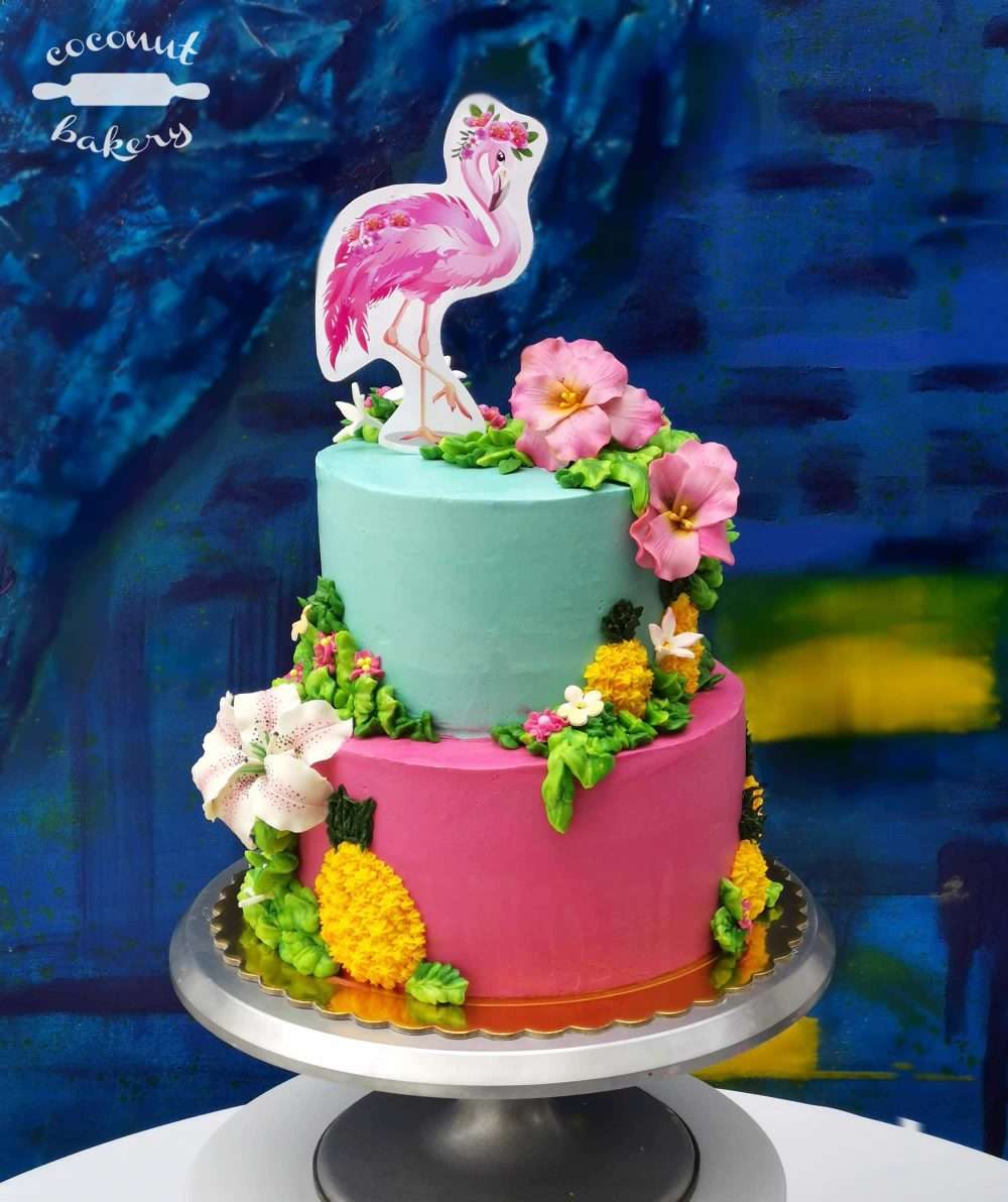 Una torta de cumpleaños con escenario tropical con un glamoroso flamingo