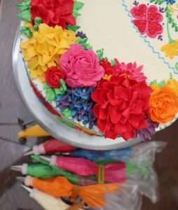 Tarta decorada con flores de crema coloridas.