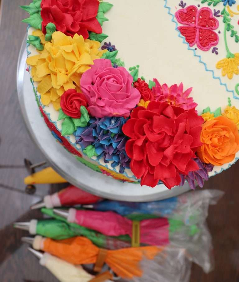 Tarta decorada con flores de crema coloridas.