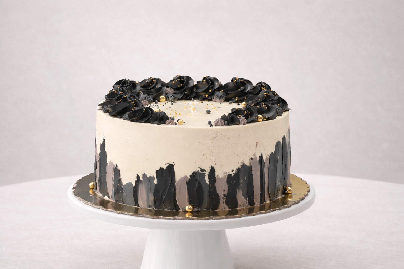 Tarta elegante con decoraciones negras y doradas.